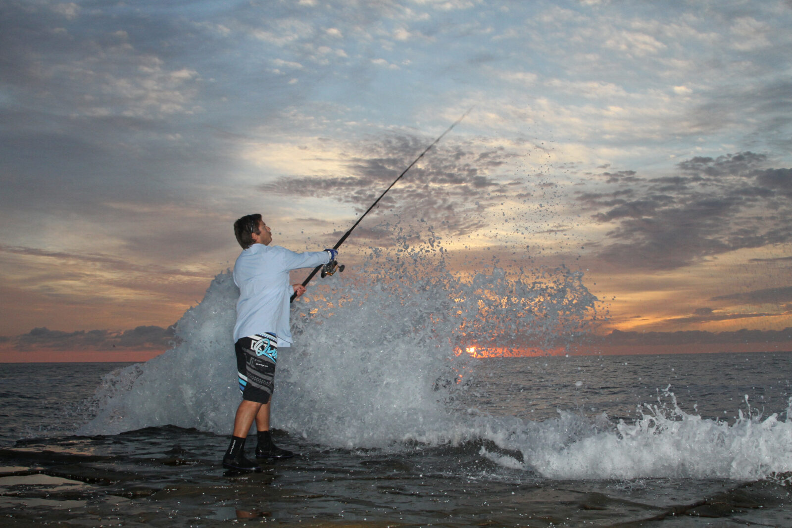 Fishing Rod With Lure At Sunset Over A Lake Photograph by Alex